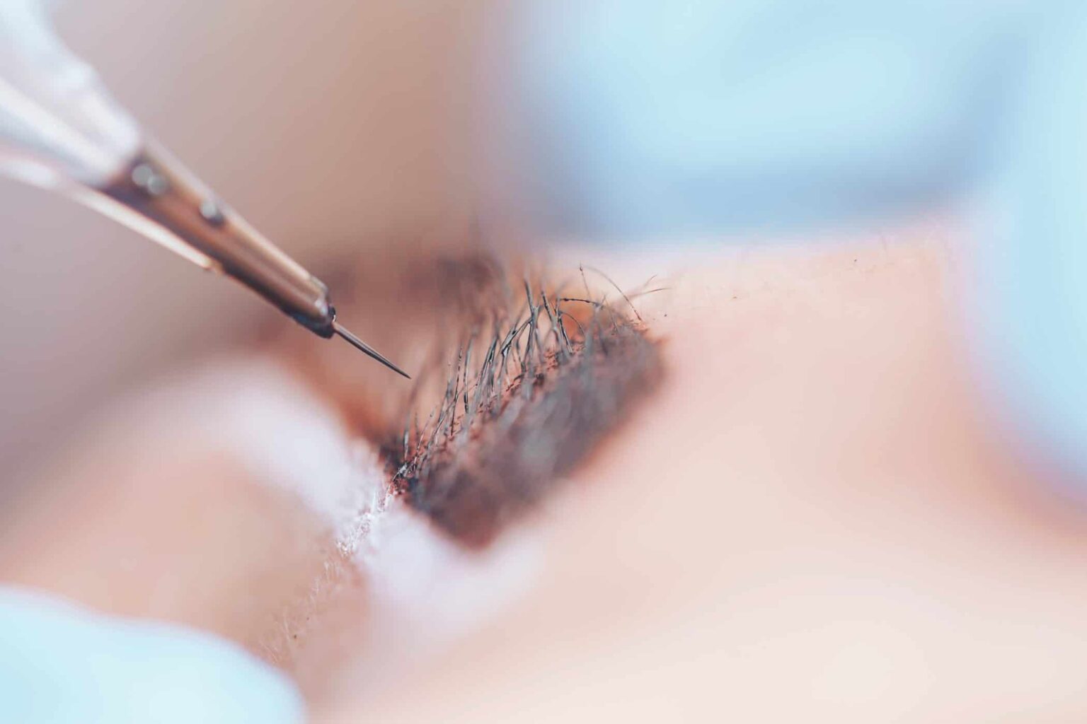 beautician making a permanent make-up procedure on eyebrows using a machine, macro photo of needle